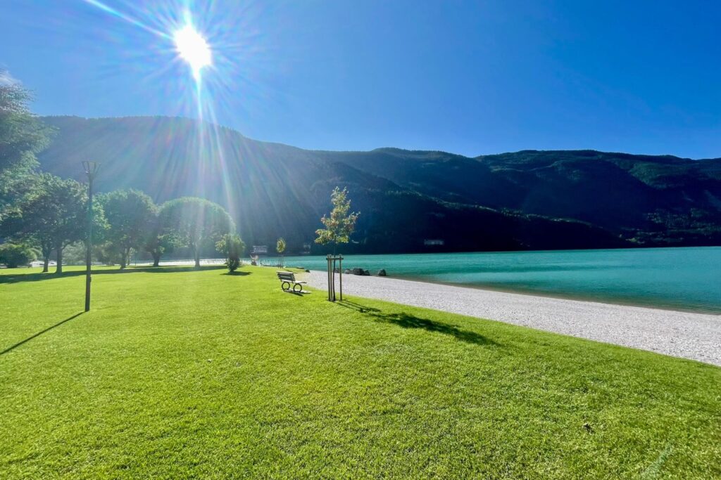 Campingurlaub am türkisblauen Molvenosee mit schöner Bergkulisse .