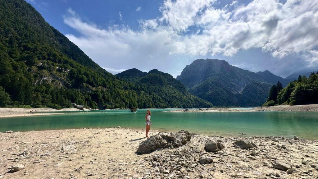 Blick über den Lago del Predil mit Kiesufer und imposanter Bergkulisse