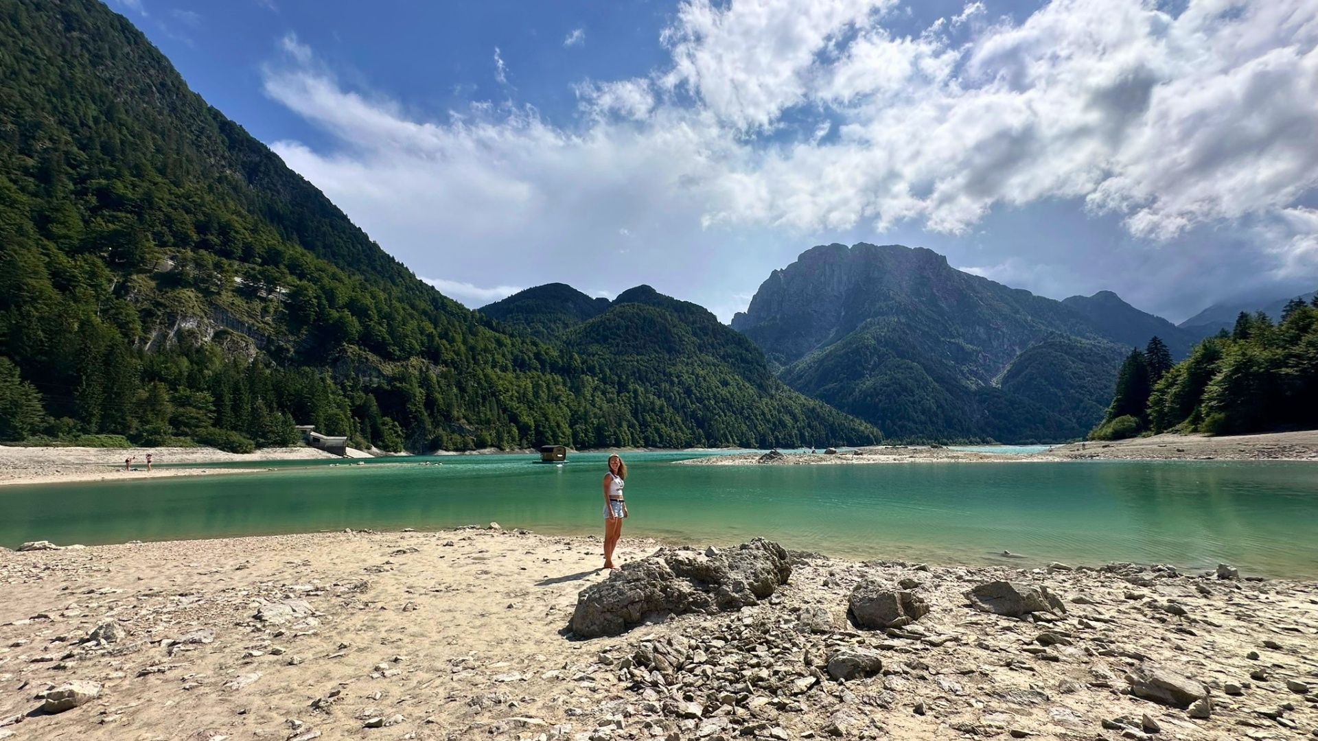Blick über den Lago del Predil mit Kiesufer und imposanter Bergkulisse